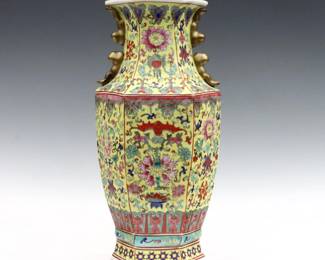 A Chinese Famille Rose porcelain vase.  Hexagonal form with enameled floral design and auspicious symbols on a Yellow ground.  Painted seal with characters.  Some surface wear, slight crazing, staining to interior.  15 1/4" high.  
