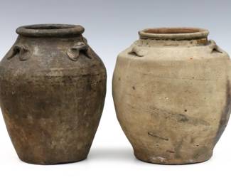 Two early Chinese Martaban stoneware storage jars.  Both having ovoid bodies with high shoulder and four applied handles.  Wear commensurate with age, each with chips to rim.  Up to 7 1/2" high.  