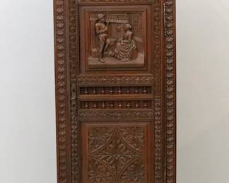 A late 19th century French side cabinet from the Brittany region in northwest France.  Oak construction with hand carved rural scenes and spindlework detail features a shaped gallery over a single long door and lower drawer, shaped lower apron.  Original finish with minor wear.  Original wrought iron hardware.  27 1/2 x 15 x 69" high overall.