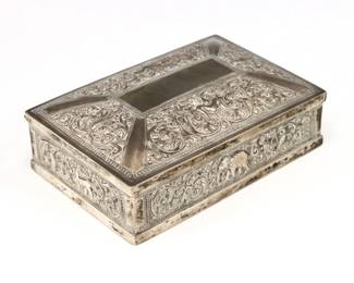 A turn of the century Silver box, likely Indian.  Rectangular hinged box with floral repousse and engraved decoration with Elephants, Lions and Birds and wood lined interior.  Hallmarked (n.d.), tested .800 Silver or higher.  Some surface wear.  6 x 4 x 2 1/4" high overall.  
