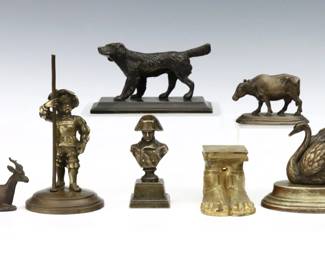 Seven 19th to 20th century small Bronze figures.  Includes a figure of a boy Musketeer, a Setter hunting dog, a Swan, a pair of Grecian style sandaled feet, a miniature bust of Napoleon, a standing Bull, and seated Deer.  Overall wear to patina and minor pitting, Swan lacks some element between wings, Napoleon bust reattached to base.  Up to 6 1/4" high.  
