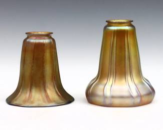 Two early 20th century Art Glass lamp shades.  Flared and bell form with Iridescent Gold finish.  Minor surface wear, a few tiny flakes to fitters.  Up to 6 1/2" high, both with 2 1/4" fitters.  
