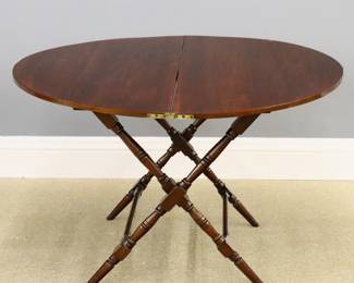 A late 19th century folding coaching table made by Thornton and Herne, London.  Mixed wood construction with folding circular top on an X-form base with turned supports.  Retains original "Thornton and Herne" tag.  Older refinishing with some wear.  41" diameter (open) x 26" high, 45" high overall when closed.