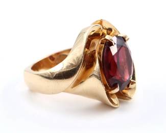 A 14k Gold and Rhodalite Garnet ring custom made by Yanke Designs, Traverse City, MI.  Features an oval cut prong set Garnet approx. 10 1/2 x 13 mm, on a wide band with squared bottom.  Marked "14k" and "Yanke Designs".  14.2 grams total.  Some surface wear.  Size 6 1/4.