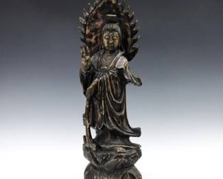 A Chinese carved hardwood figure of Guan Yin.  Depicted standing with hand raised on an incorporated base.  Refinished with some shrinkage.  25 1/2" high.  
