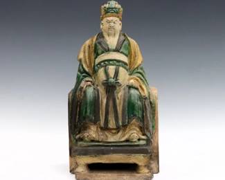 A Chinese Tang style Terracotta figural roof tile.  Depicts a seated emperor with Sancai glaze.  Wear and weathering, lacks right hand, minor damage.  15 1/4" high.  
