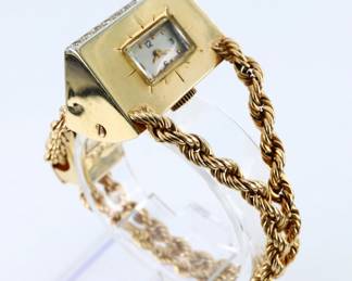 A vintage 14k Gold ladies bracelet wristwatch with Diamonds.  Features a 14k Gold triangular case with prong set Diamond stars, each approx. 2mm, and Diamond chip accents on a double rope chain bracelet with heavy Gold clasp featuring additional Diamonds.  17j, manual wind Swiss movement with Silvered dial and Arabic numerals.  Clasp marked "14k" and "103".  49.1 grams total.  Case with some surface wear and slight denting, winds, sets and running when cataloged.  5 3/4" interior circumference, 7" long open.