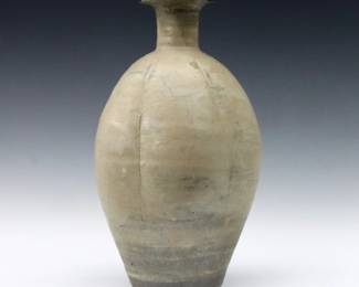 An early Chinese stoneware vase.  Lobed body with cylindrical neck and White/Gray glaze.  Wear commensurate with age, crazing and some flakes, chip to rim.   
