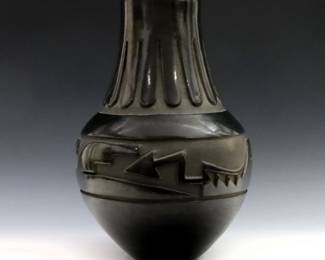 An early to mid 20th century Santa Clara Pueblo Earthenware jar.  Bulbous form with deeply carved "Avanyu" serpent decoration and polished black glaze.  Attributed to Agapita Tafoya at underside.  Crazing, flake at rim and carved decoration on body, minor surface wear.  14 1/4" high.  
