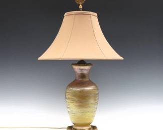 An early 20th century Art Glass lamp attributed to Durand.  Baluster form vase with Iridescent Gold finish and threaded decoration on Gilded Bronze mounts with a later silk shade.  Lamp base marked "MS & Co" at underside.  Vase with losses to threaded decoration and some surface wear, wear to patina.  Vase is 12" high, 27 1/2" high overall.  
