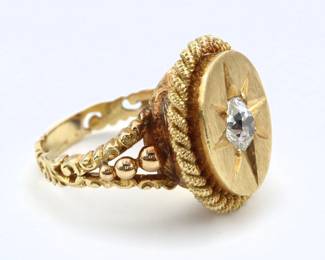 A vintage 18k Gold and Diamond gent's "poison" ring.  Features a hinged top with prong set round cut Diamond star, approx. 5 mm and estimated 0.5 ct, covering a small compartment with roped trim on an engraved band with openwork design.  Unmarked, tested 18k.  12.2 grams total.  Hinged cover does not stay closed, may have been sized.  Size 8 3/4.