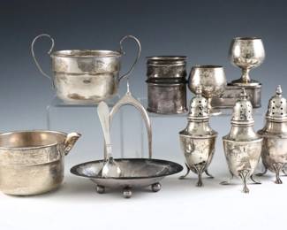 Fourteen pieces of Sterling Silver tableware.  Includes a two pairs of Webster salt and pepper shakers, a Georg Jensen salt dish with spoon, a Webster creamer and open sugar, two Gorham cordials, a pair of wishbone ice tongs, and three napkin rings.  Each marked "Sterling".  14.10 troy ozs total.  Some wear and minor damage, two napkin rings inscribed.  Up to 4" high.  
