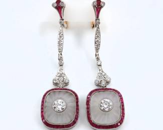 A pair of vintage 14k White Gold drop earrings with Diamonds and Rubies.  Art Deco style, features engraved Rock Crystal pendants with bezel set round cut Diamonds, each approx. 4.5 mm, surrounded by channel set Ruby accents, on matching drops with hinged pierced backs.  Unmarked, tested 14k.  8.8 grams total.  Minor wear.  1 3/4" long.
