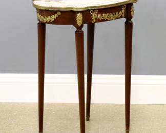 An early 20th century French side table.  Walnut construction with Gilded Bronze mounts and inset shaped Marble top on tall tapered legs.  Original finish with minor wear, chip to veneer at edge of apron.  24 x 15 3/4 x 29" high overall.