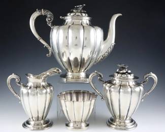 A four piece Mexican Sterling Silver tea set.  Lobed bodies with floral decoration, includes a teapot, creamer, covered sugar and open waste bowl.  Various marks, teapot marked "Sterling Mexico", creamer and sugar with "Plateria Alameda Juarez" and "Sterling / Mexico" marks, waste bowl with "Tobias. A / Sterling / Mexico" marks.  70.48 troy ozs total.  Some surface wear, teapot with minor damage at spout and bent hinge.  Up to 8 1/2" high.  
