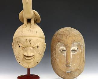 Two 20th century African wooden masks.  Includes a Yoruba Gelede style mask with a carved Bird at top, and a Congolese Lega style mask.  Yoruba mask with faint traces of original paint, some wear and minor damage.  Up to 11" high.  
