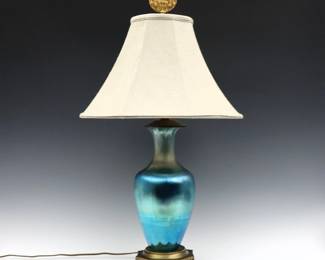 An early 20th century Art Glass lamp attributed to Steuben.  Baluster form vase with ribbed body and Blue Aurene finish on pierced Gilded metal mounts with a later silk shade.  Minor surface wear and some scratches to vase, wear to patina.  Vase is 12" high, 29" high overall.  
