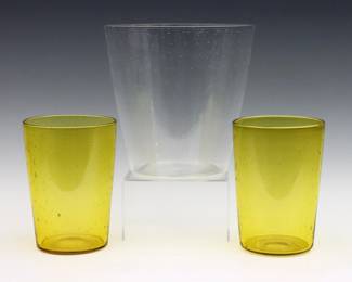 Three early 20th century Steuben Art Glass vases.  Tapered cylindrical forms with controlled bubble decoration in clear and Bristol Yellow.  Clear and one Yellow vase with acid etched "Steuben" mark, other vase attributed.  Some surface wear, clear vase with long scratches.  Up to 8 1/2" high.  
