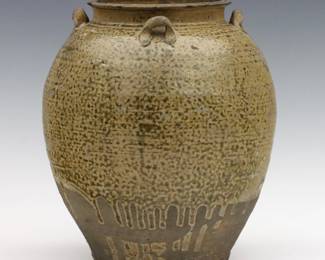 An early Chinese Martaban stoneware storage jar.  Ovoid form with four applied handles and drip glaze.  Wear commensurate with age, chips to rim.  8 1/2" high.  
