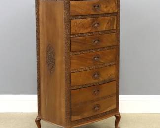 An early 20th century lingerie chest.  Walnut construction with carved foliate design, six long drawers and recessed finger pulls on short cabriole legs.  Original finish with minor wear, top with minor fading, scratches and a watermark.  24 1/2 x 17 1/2 x 48 1/4" high overall.