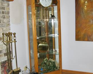 Howard Miller Oak Eternity Floor Clock with glass display shelving: 27" x 13" x 84" &nbsp;$495 Please contact Diana via text or phone 708-670-2189 to arrange&nbsp;payment or with any questions.&nbsp;
