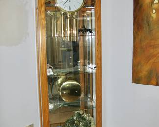 Howard Miller Oak Eternity Floor Clock with glass display shelving: 27" x 13" x 84" &nbsp;$495 Please contact Diana via text or phone 708-670-2189 to arrange&nbsp;payment or with any questions.&nbsp;