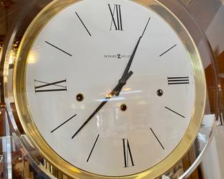Howard Miller Oak Eternity Floor Clock with glass display shelving: 27" x 13" x 84" &nbsp;$495 Please contact Diana via text or phone 708-670-2189 to arrange&nbsp;payment or with any questions.&nbsp;