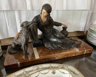 Iconic bronze, pewter and ivorene Art Deco statue by Manneville and Rochard (Ugo Cipriani's pseuidonym is "Manneville" and Irenee Rochard) circa 1930. Features a lady donning a flapper dress in repose flanked by two greyhound dogs in silvered pewter presented on an onyx and marble base in celadon and variegated tawny veins. Lady's hands and face are rendered in nude hued hand-carved bone, With its iconically Art Deco sensibility and materials and excellent vintage condition.