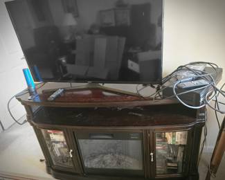 Fire place and storage with a Samsung smart t.v. on it.