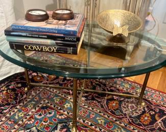Oval beveled glass top coffee table with hoof feet base, 9’ x 12.5’ rug