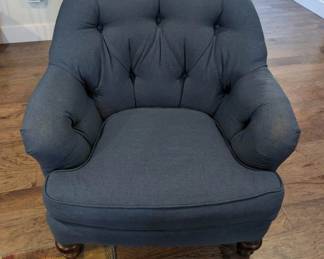 oversized blue upholstered chair with wooden bun feet, woodland plaid rug