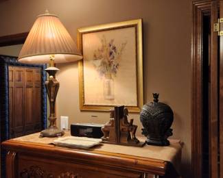 Lamp, radio, and other decor on chest + framed under glass picture