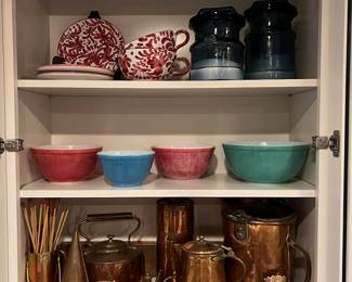The top shelf has Italian pottery, The middle shelf has vintage Pyrexx. And the bottom shelf has a wonderful collection of copper.