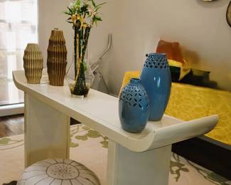 Oriental style end table, pottery, large gold wall decor. Rug and leather ottoman