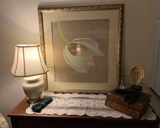 Lamp, books and large floral hold framed art