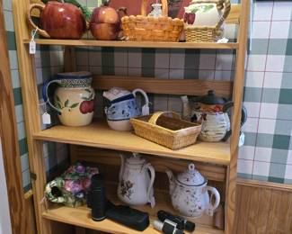 This shelf is outside of the pantry and on the wall opposite of the staircase that leads to the attic.