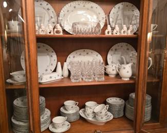 The fine china in this cabinet features lovely purplish roses.