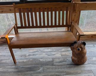Wooden bench and a hugging bear statue