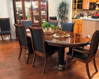 large dining room table and upholstered chairs that has extra leaves and padded top
