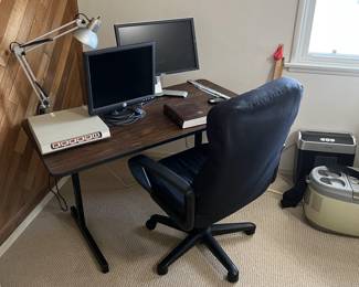 There are a few office pieces: two monitors, a flat power strip, desk, and office chair.  Almost out of view is a paper shredder.