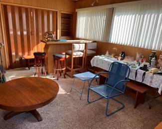 Another look at the room's contents, including the tall chairs at the bar, a round, wooden coffee table, and a pair of round barstools.