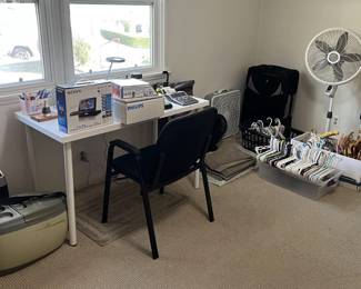 More desk and/or office furniture is shown here.  There are also a bunch of clothes hangers, a powered automotive ice cooler, a standing fan, TV trays, and more.