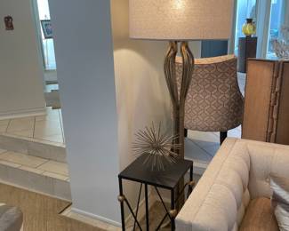 One of a pair of gold leafed floor lamps and one of a pair of black and gold stands