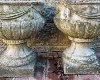 Pair of cast concrete footed urns with swag decoration