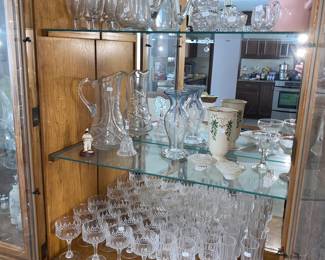 China hutch full of assorted bar and glassware