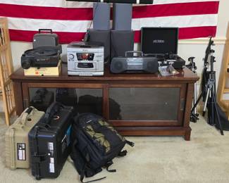 TV stand with storage, stereo + speakers, slide projector, 2 guitars, tripods, camera cases
