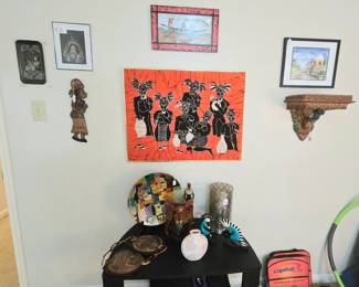 The focal point here is the fabulous, framed bright-red, fabric depicting a group of musicians, it's surrounded by a collection of other pieces from various cultures.  