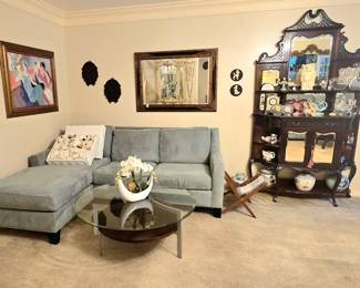 Furnishings include several antique/vintage curio cabinets, 2 wingback chairs with wood-base ottomans, 2 powder blue couches, various occasional tables, end tables, coffee tables, etc