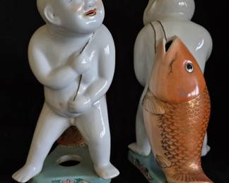 Pair of matching 'boy with fish' figurines