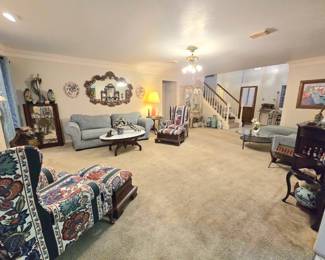 Furnishings include several antique/vintage curio cabinets, 2 wingback chairs with wood-base ottomans, 2 powder blue couches, various occasional tables, end tables, coffee tables, etc